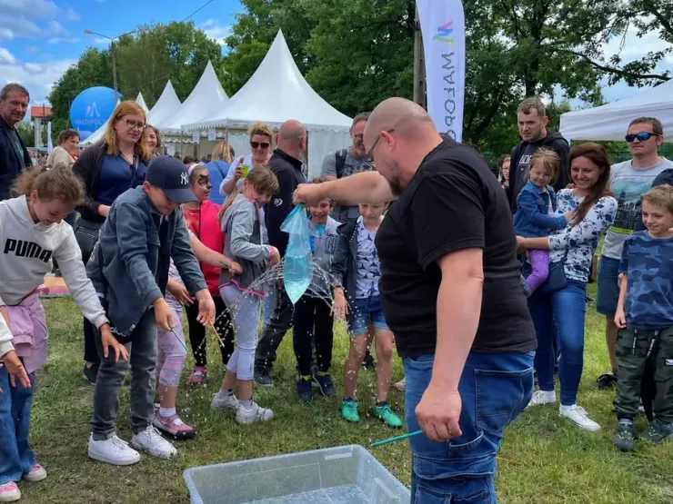 Dzieci i Maciej Gomułka podczas eksperymentu z wodą na festynie